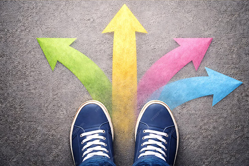 Student loan borrower decision tree after SAVE plan ends Four colored arrows point in different directions. A pair of blue sneakers is seen at the bottom edge of the photo